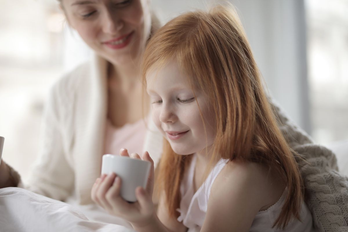 A mother and daughter sharing a cozy morning moment, savoring hot drinks in bed. - Photo by Andrea Piacquadio on Pexels