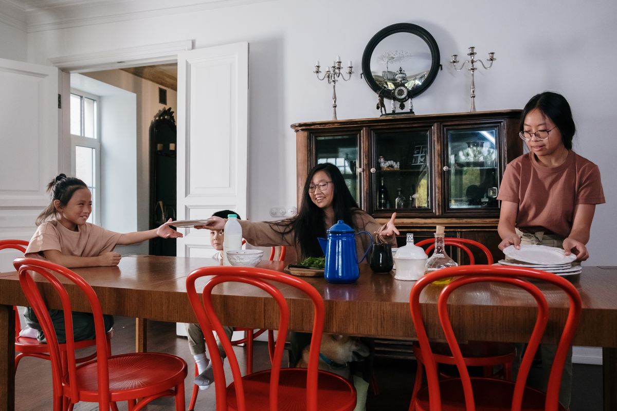 Siblings tidying up the dining table together, showcasing teamwork and family bonding. - Photo by cottonbro studio on Pexels