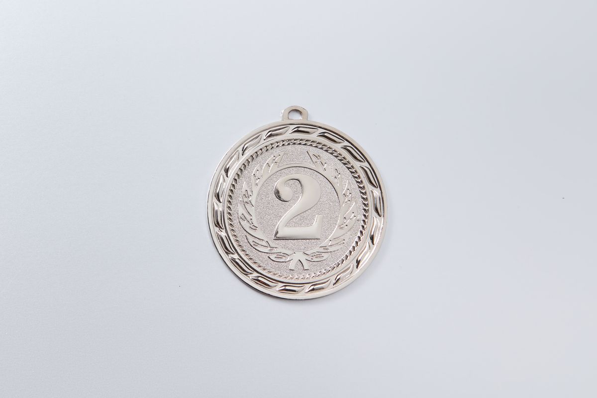 Close-up of a silver second place medal with an engraved number 2 on white background. - Photo by DS stories on Pexels