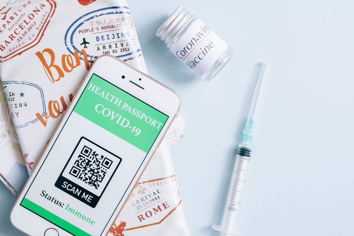 Image of a smartphone displaying a COVID-19 health passport next to a vaccine vial and syringe, ready for travel. - Photo by Leeloo The First on Pexels