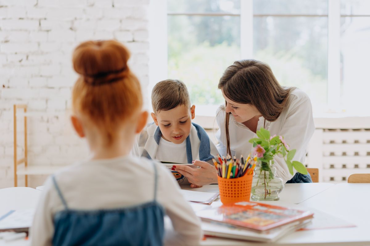 Spannendes Lernerlebnis mit einem Lehrer und einem Kind, die in einem hellen Klassenzimmer Bücher und Kreativität erkunden. - Foto von Mikhail Nilov auf Pexels