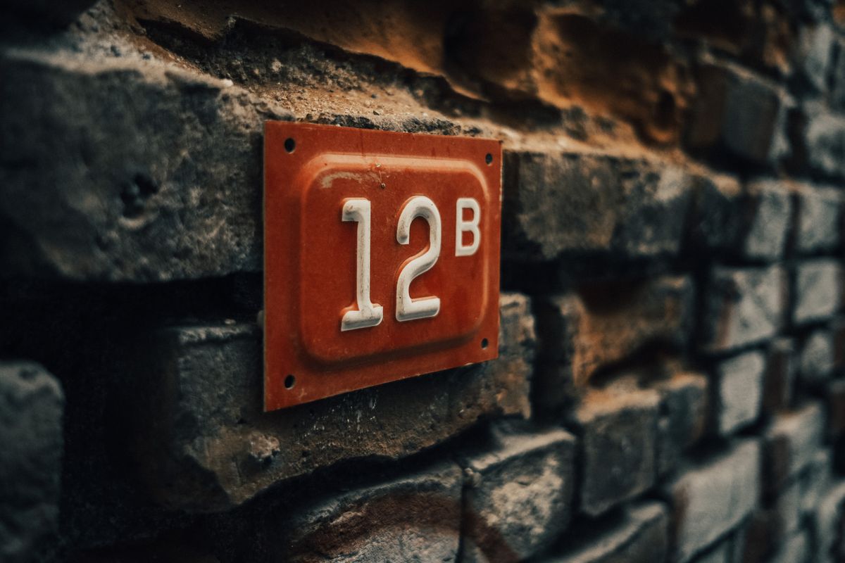 Close-up of a vintage apartment number 12B on a textured stone wall. - Photo by Sami  Aksu on Pexels