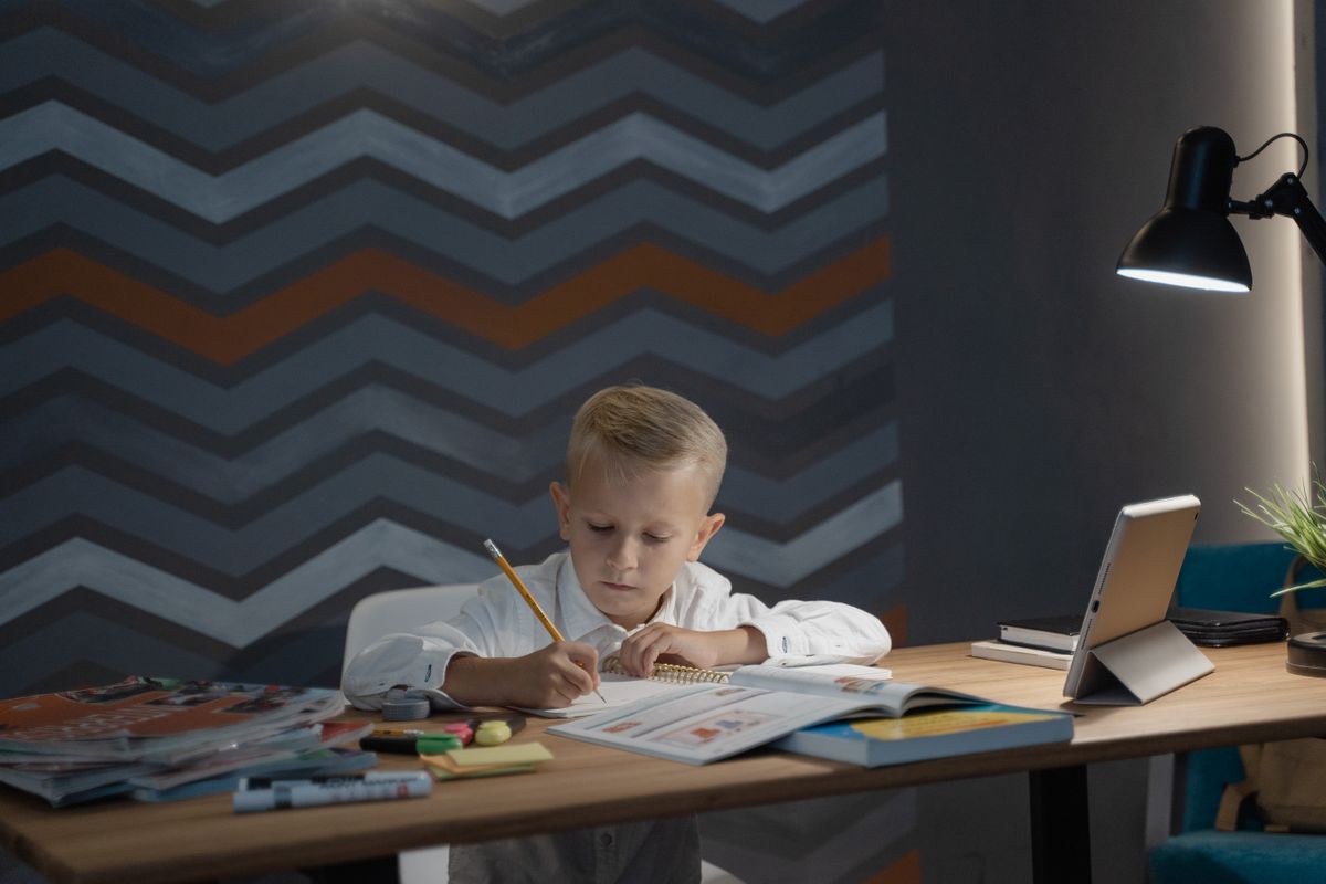 A child doing homework beside a tablet - Photo by Tima Miroshnichenko on Pexels