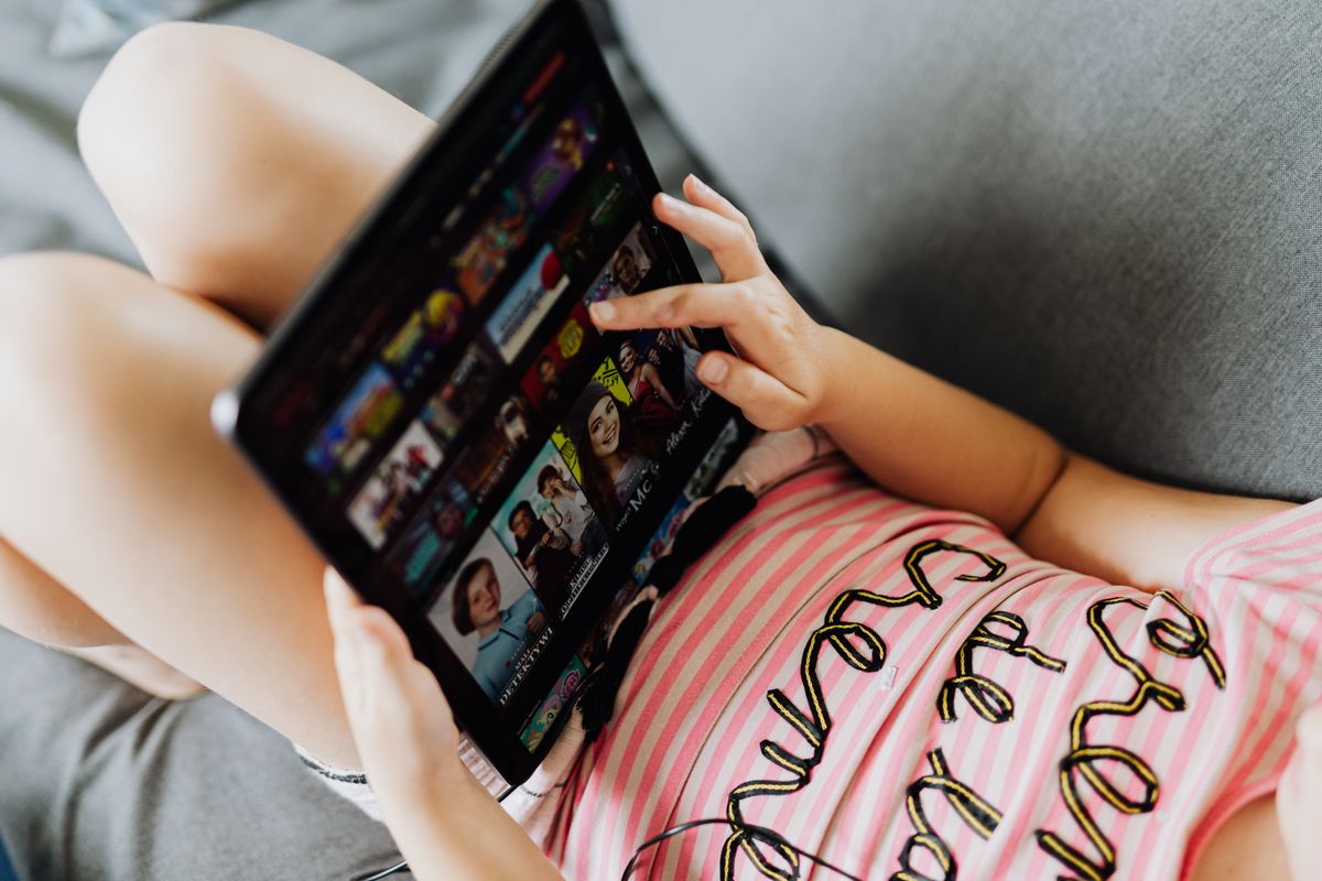 Junges Mädchen, das sich hinlegt und ein Tablet zur Unterhaltung und zum Lernen im Innenbereich nutzt. - Foto von www.kaboompics.com auf Pexels