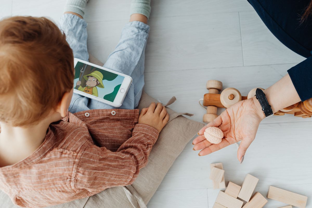 A mother and child sitting on the floor watching a cartoon on a tablet. - Photo by www.kaboompics.com on Pexels